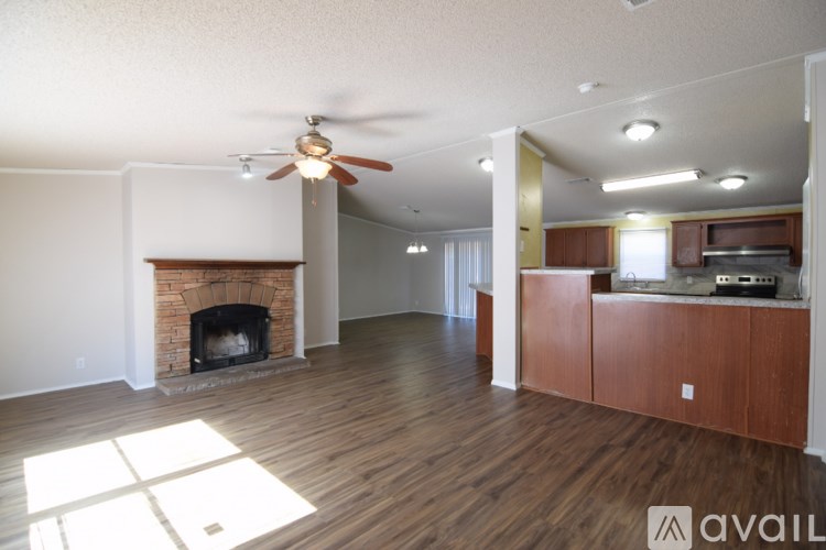 A living room with a fireplace and a ceiling fan.