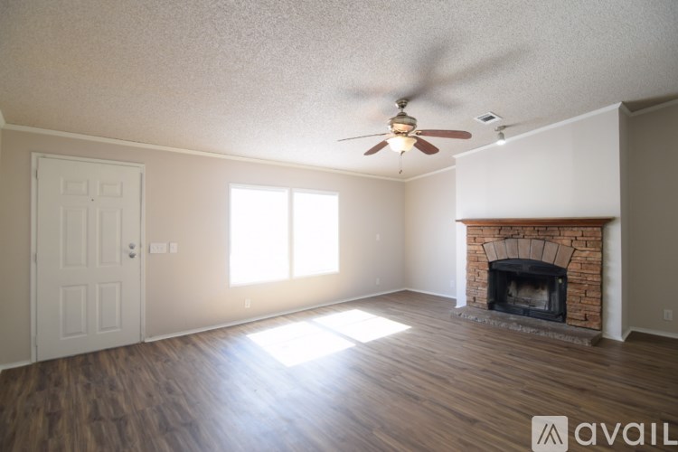 A room with a fireplace and a ceiling fan.