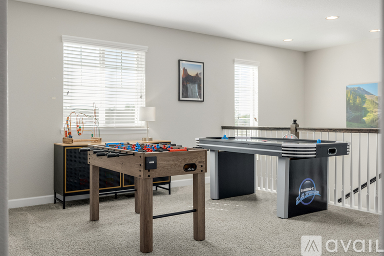 A room with a pool table and a foosball table.