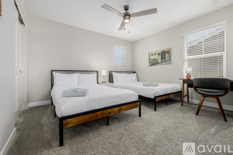 A bedroom with two beds and a chair.
