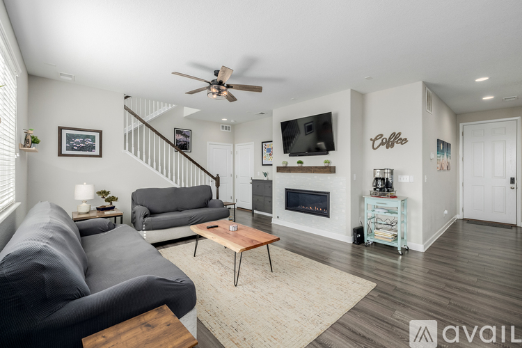 A living room with a grey couch, a coffee table, a fireplace, and a television.