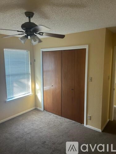 A room with a ceiling fan and a door.