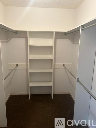 A white walk-in closet with shelves and a door.