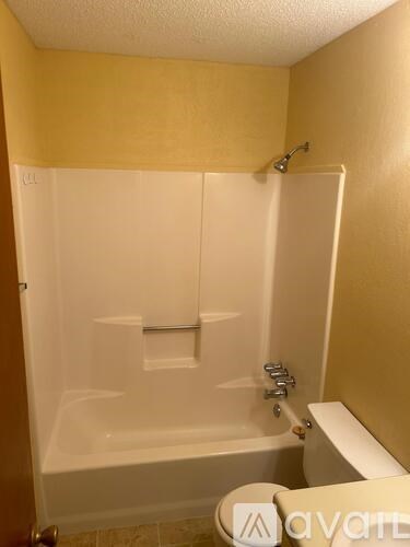 A bathroom with a white tub and toilet.