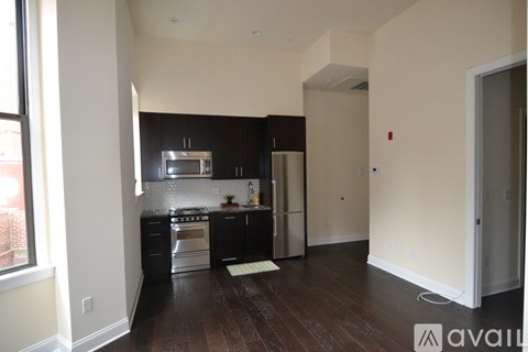 A kitchen with black cabinets and stainless steel appliances.