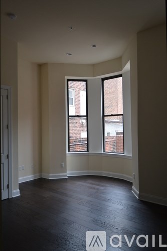 A room with a large window and a view of a brick building outside.