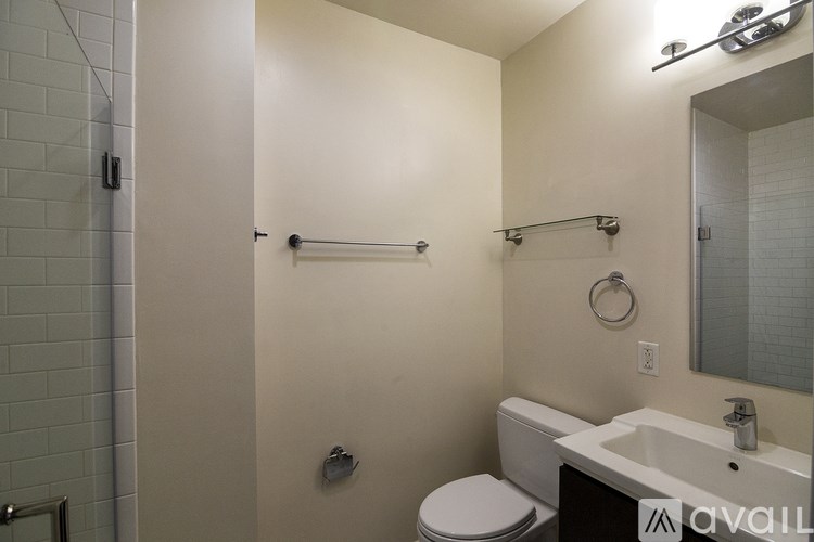 A bathroom with a toilet, sink, and a mirror.