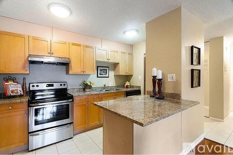 A kitchen with a black stove top oven and wooden cabinets.