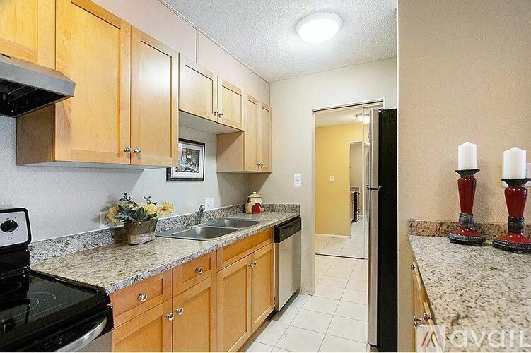 A kitchen with wooden cabinets and granite countertops.