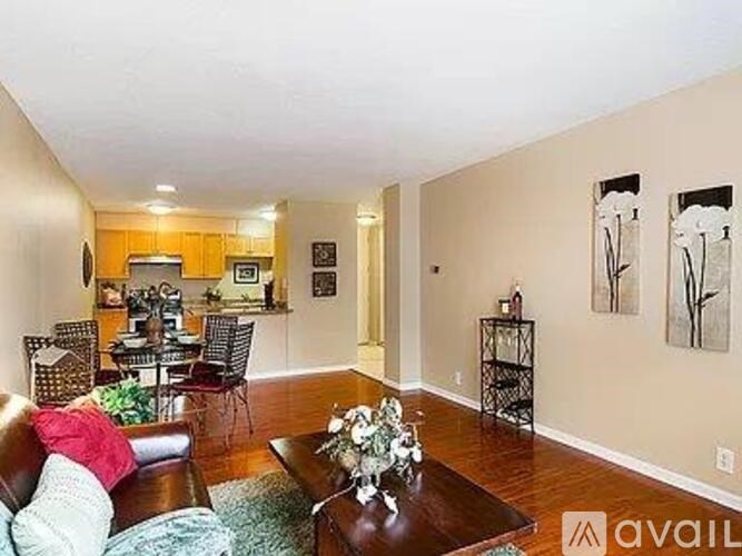 A living room with a brown leather couch and a coffee table in the center.