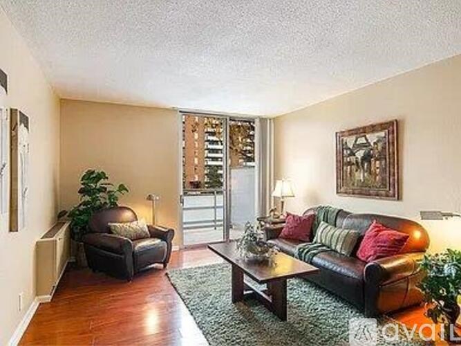 A living room with a black couch and a brown leather couch.