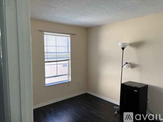 A room with a window and a floor lamp.