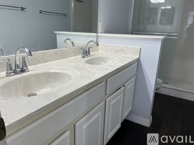 A bathroom with two sinks and a large mirror.