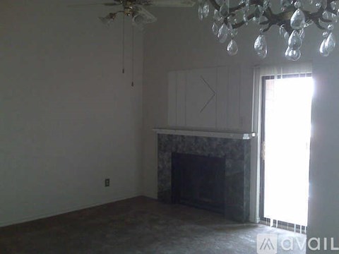 A living room with a fireplace and a chandelier.