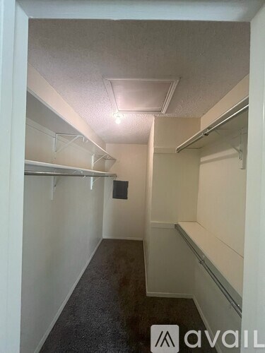 A white hallway with a carpeted floor and white walls.