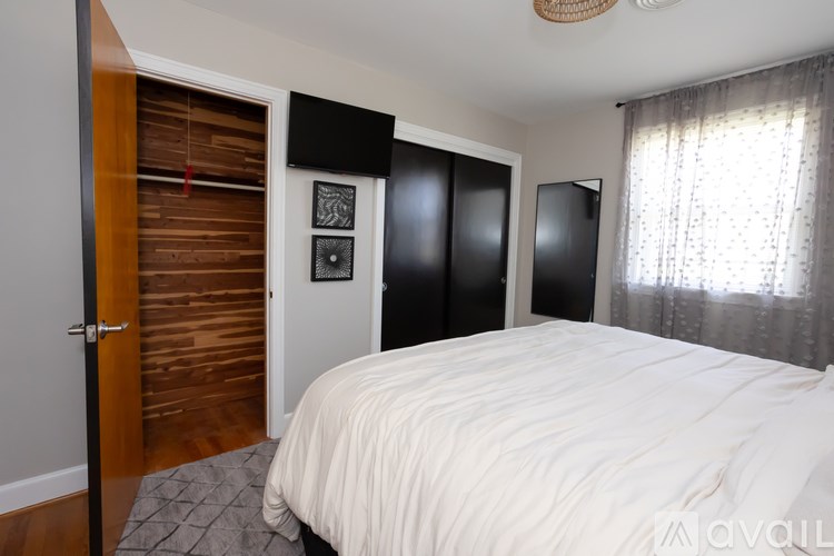 A bedroom with a white bed and a wooden door.