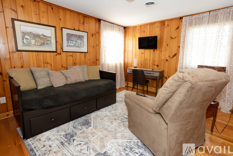 A cozy living room with a couch, chair, and a television.