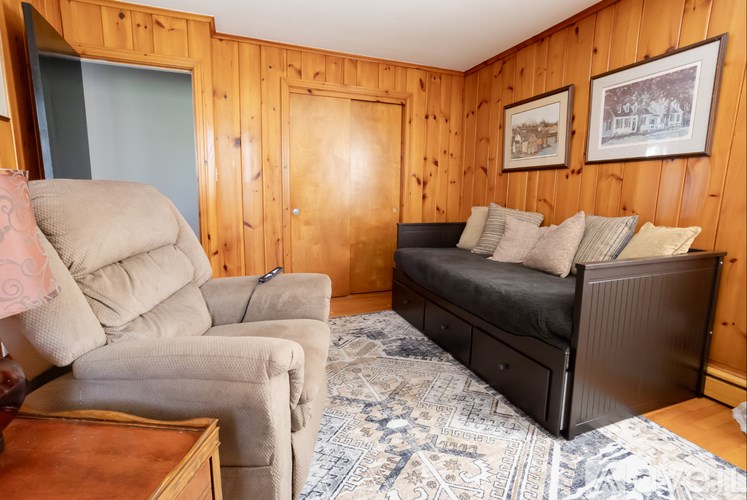 A bedroom with a bed, couch, and chair.