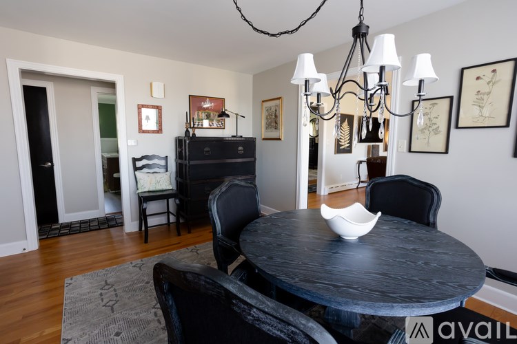 A dining room with a black table and chairs.