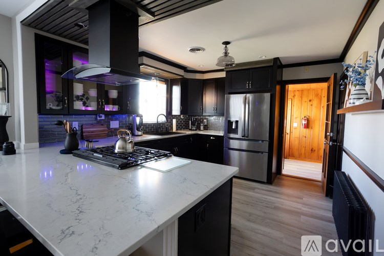 A modern kitchen with a marble countertop and stainless steel appliances.