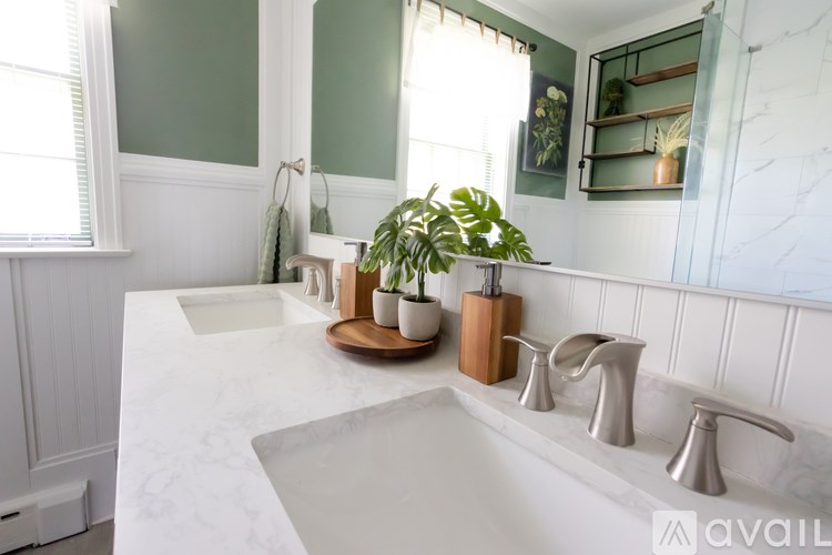 A bathroom with a marble countertop and a large mirror.