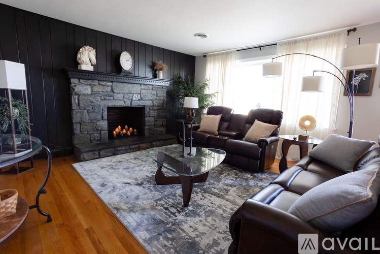 A living room with a fireplace and a glass coffee table.