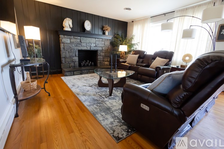 A living room with a fireplace and leather couches.