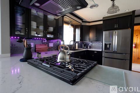A modern kitchen with a black stove top and a glass counter top.