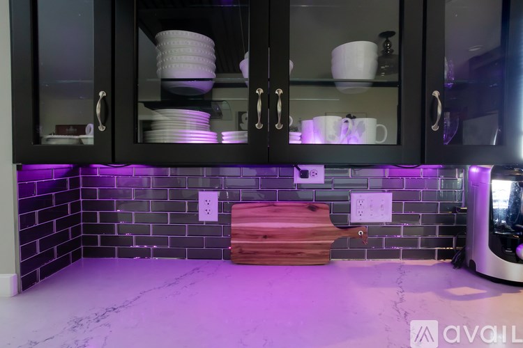 A kitchen with black cabinets and a wooden cutting board.