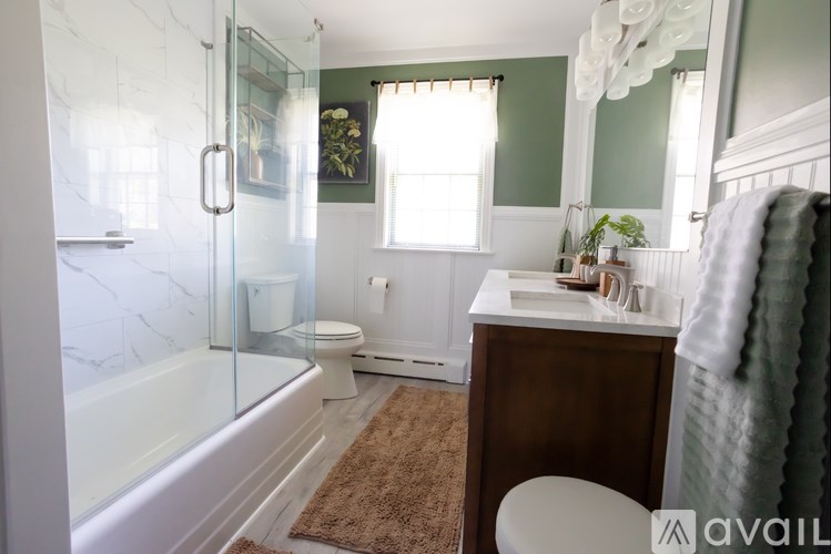 A bathroom with a white tub, toilet, and sink.