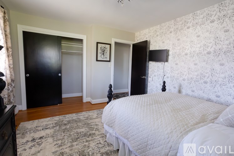 A bedroom with a large bed and a black wardrobe.