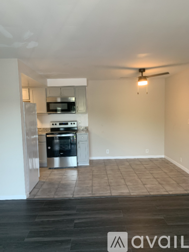 A kitchen with a refrigerator, oven, and microwave.