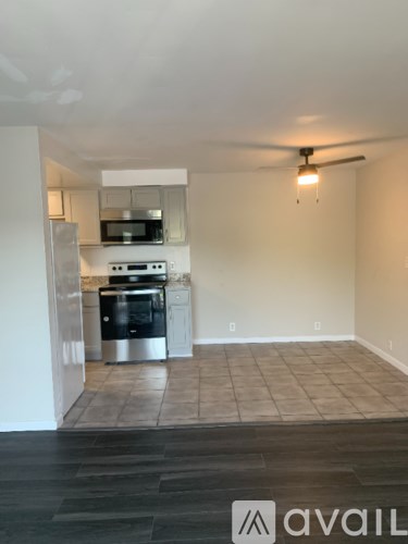A kitchen with a refrigerator, oven, and microwave.