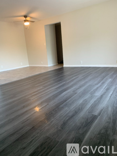 A room with wooden flooring and a ceiling fan.