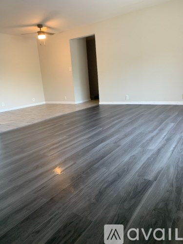 A room with wooden flooring and a ceiling fan.