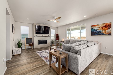 A living room with a grey couch, a wooden coffee table, and a painting on the wall.