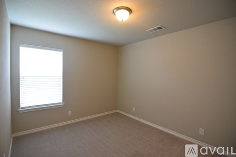 A room with a window and carpeted floor.