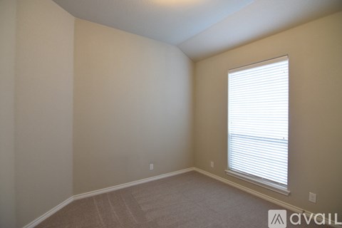 A room with a window and carpeted floor.