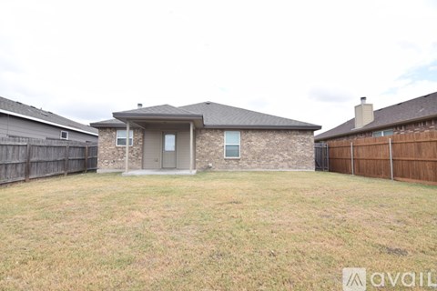 A house with a brown fence and a grey roof is available for rent.