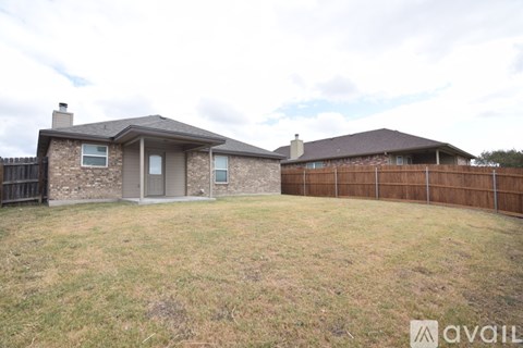 A house with a brown fence and a grey door is available for sale.