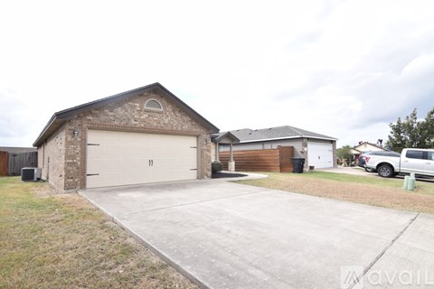 A two-car garage with a brick wall and a white door is in the foreground.