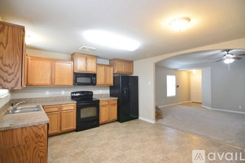 A kitchen with wooden cabinets and black appliances.