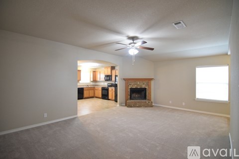 A living room with a fireplace and a ceiling fan.