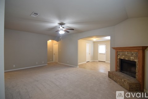 A living room with a fireplace and a ceiling fan.