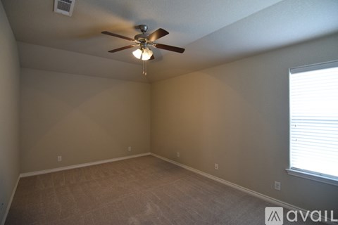 A room with a ceiling fan and carpeted floor.