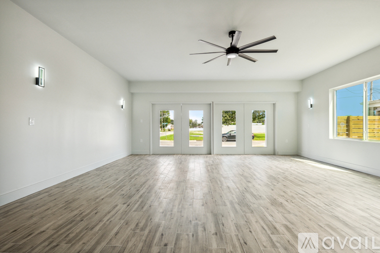 A spacious room with a ceiling fan and sliding glass doors.
