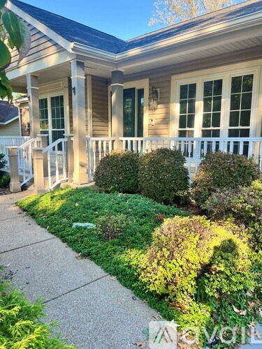 A house with a front yard and bushes.