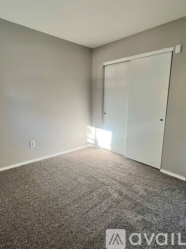 A room with a carpeted floor and a white door.