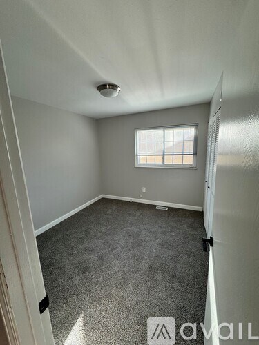 A room with a window and carpeted floor.