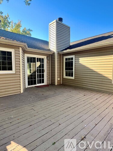 A wooden deck with a chimney and two windows.